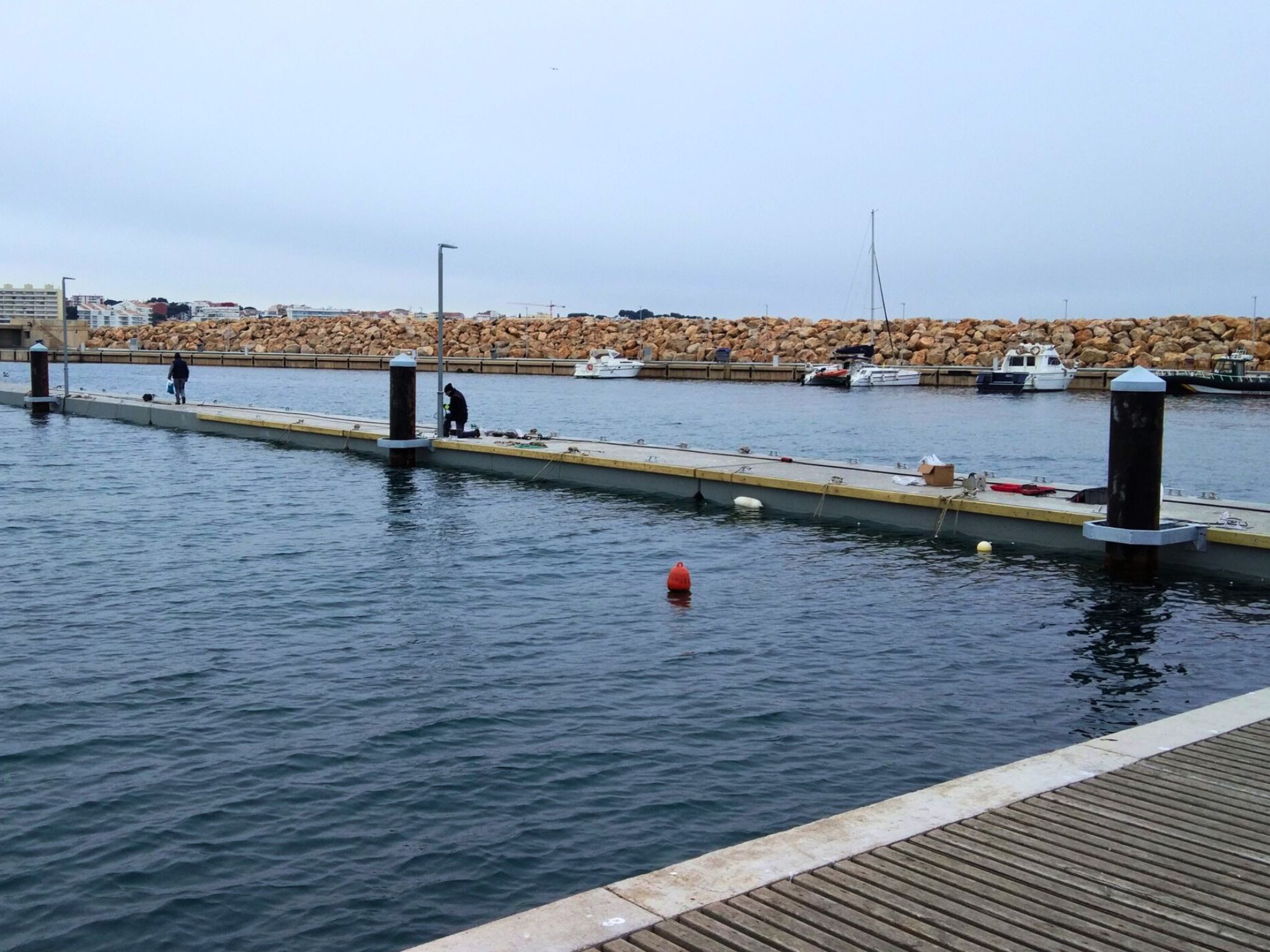 Floating concrete pontoons are used for mooring boats in sheltered harbors