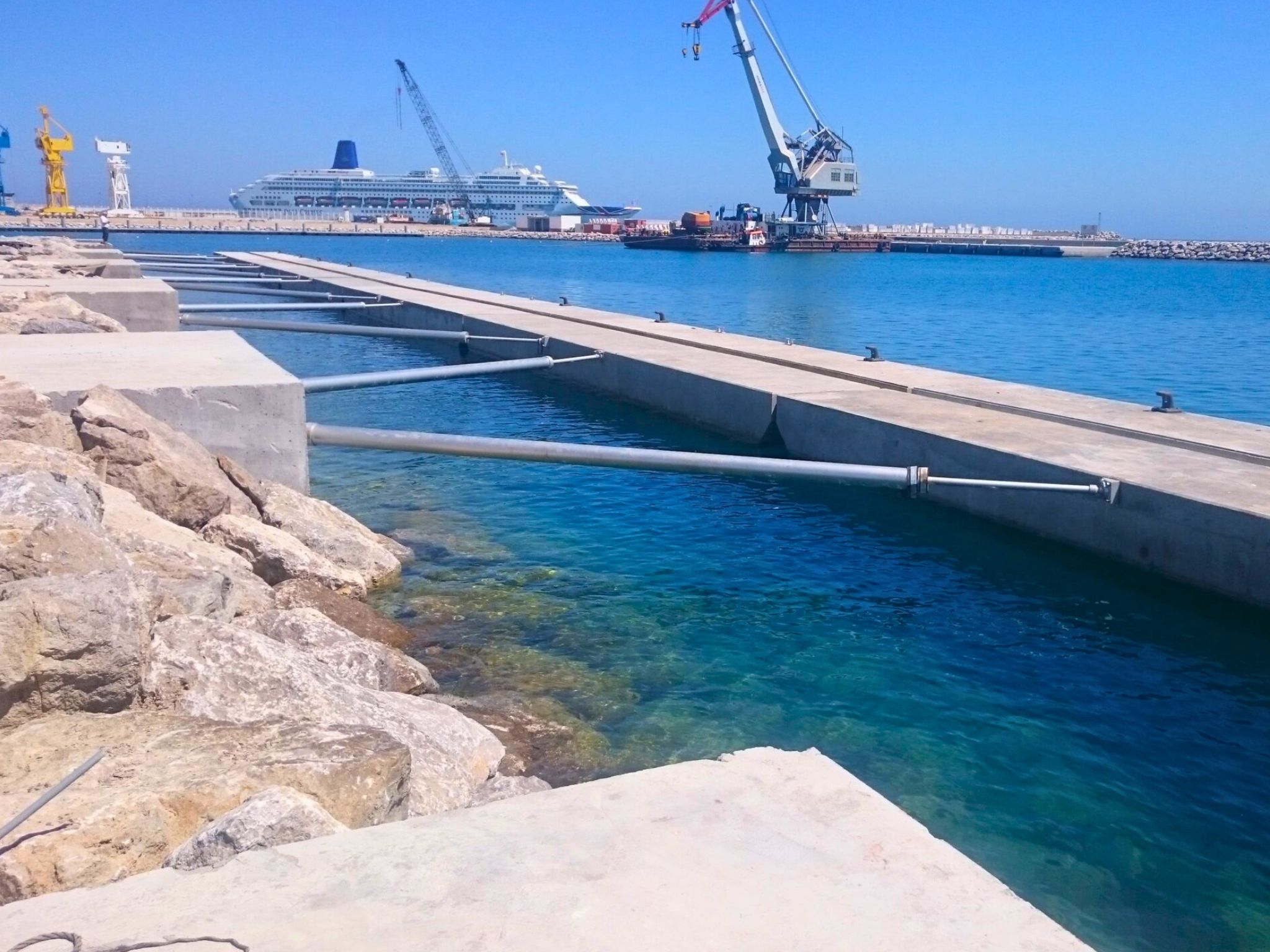 Damped tie-downs are used to secure floating structures parallel to piers or breakwaters, replacing traditional systems with rigid mooring arms